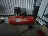 un compresseur d'air rouge posé sur le sol d'un garage