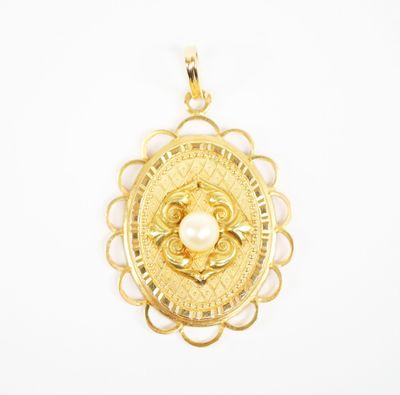 a close up of a gold pendant with a pearl in the center