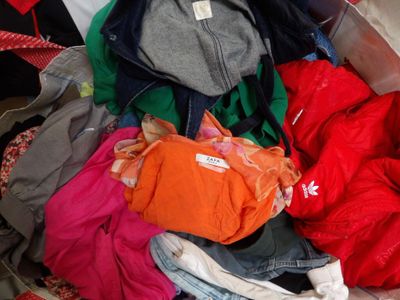 a pile of clothes in a suitcase on the floor