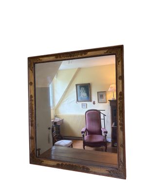 un miroir dans lequel se reflète une chaise dans une pièce