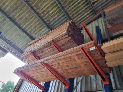 plusieurs pièces de bois sont empilées dans un entrepôt
