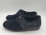 a pair of black shoes on a white surface