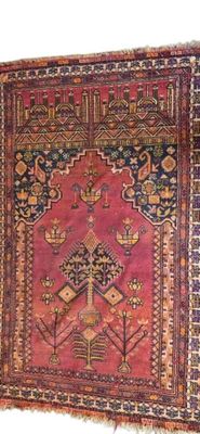 un tapis ancien avec un fond rose et un motif sur le bas