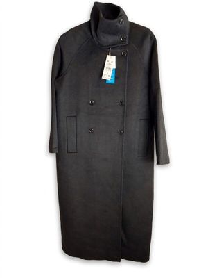Le manteau est noir et porte une étiquette bleue.