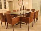 une table en verre entourée de chaises, au milieu d'une pièce