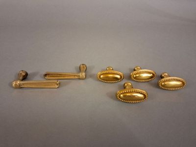 Plusieurs objets métalliques dorés sont disposés sur une surface grise