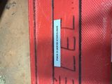 a red suitcase with a sticker on it sitting on the ground
