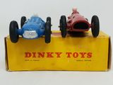 two toy cars sitting on top of a yellow box on a white surface