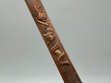 a close up of a wooden stick with a carving on it