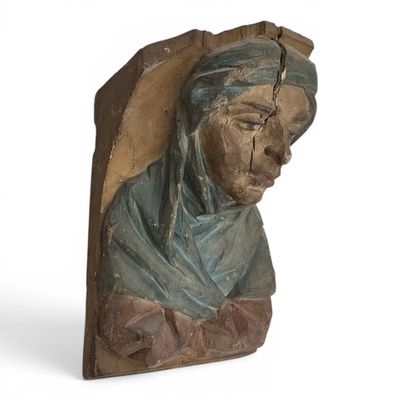 une image représentant une sculpture en bois d'une femme portant un foulard bleu