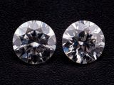 une paire de diamants de taille ronde sur un fond noir