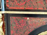 a black and red cabinet with a clock on top of it