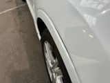 a close up of a white car parked in a parking lot