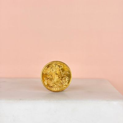 a gold coin sitting on top of a marble block