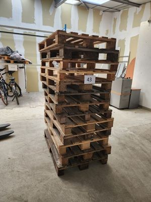une pile de palettes en bois posée dans une pièce