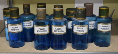 Plusieurs bouteilles contenant un liquide bleu sont alignées sur un comptoir