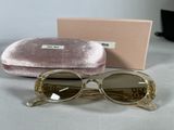 sunglasses are sitting on a table next to a pink velvet case