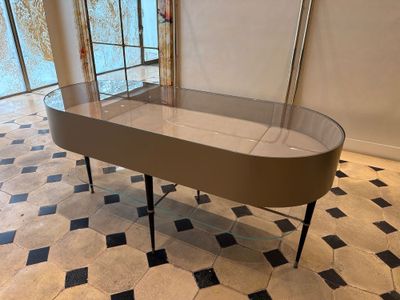 une table en verre avec un plateau en verre au milieu d'un sol carrelé