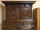 a tall wooden cabinet with a clock on top of it