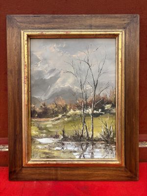une peinture à l'huile d'un paysage dans un cadre en bois sur un tapis rouge