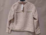 a close up of a sweater on a hanger on a wall