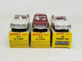 three toy cars are sitting on top of boxes on a white surface