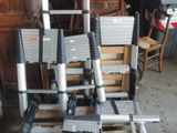 une pile d'échelles posée sur une palette dans un garage