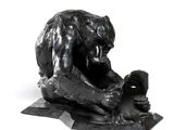 statue d'un ours assis sur un rocher, un téléphone portable à la main