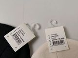 a label on the back of a black and white sweater