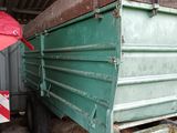 une photo d'un camion-benne vert garé dans un garage