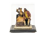 une image représentant une figurine d'un homme et d'une femme assis sur une chaise