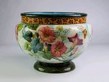un vase avec des fleurs peintes dessus, posé sur une table