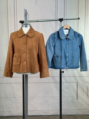 pair of jackets on a stand in front of a white wall