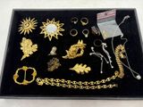 un plateau noir sur lequel sont posés des bijoux en or