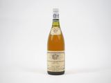 une bouteille de vin posée sur une table blanche