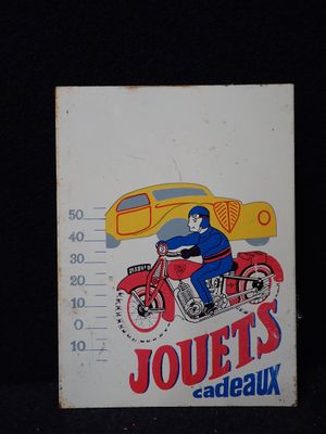 une pancarte sur laquelle on peut lire « Jouet's Sandbaux », avec l'image d'un homme à moto