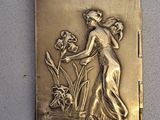a gold plated picture of a woman with flowers on it