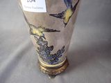 a vase with a bird on it sitting on a table