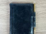un portefeuille en cuir noir sur lequel est posé un stylo