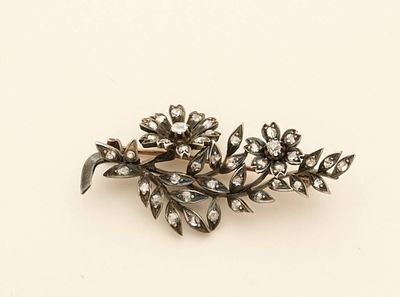 an image of a silver broochle with flowers and leaves