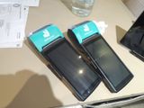 three cell phones sitting on a table next to a bottle of water