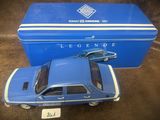 La petite voiture bleue est posée à côté d'une boîte bleue.
