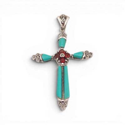 un gros plan d'une croix sur une surface blanche, avec une fleur rouge