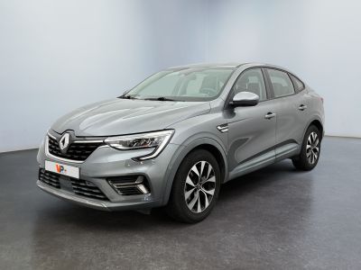 Une voiture grise est garée dans une pièce aux murs blancs.