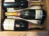 quatre bouteilles de vin dans un carton posé sur une table