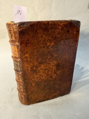 an old book with a note sticking out of it on a table