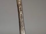 an old silver spoon with a handle that has writing on it