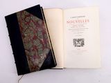 a book open on a white table with a red and black cover