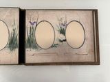 an open book with a picture of flowers and grass on it