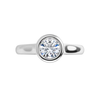 un gros plan d'une bague en diamant sur fond blanc
